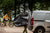Cyclist packing muddy bike into BikeParka RoughSac for transport in van